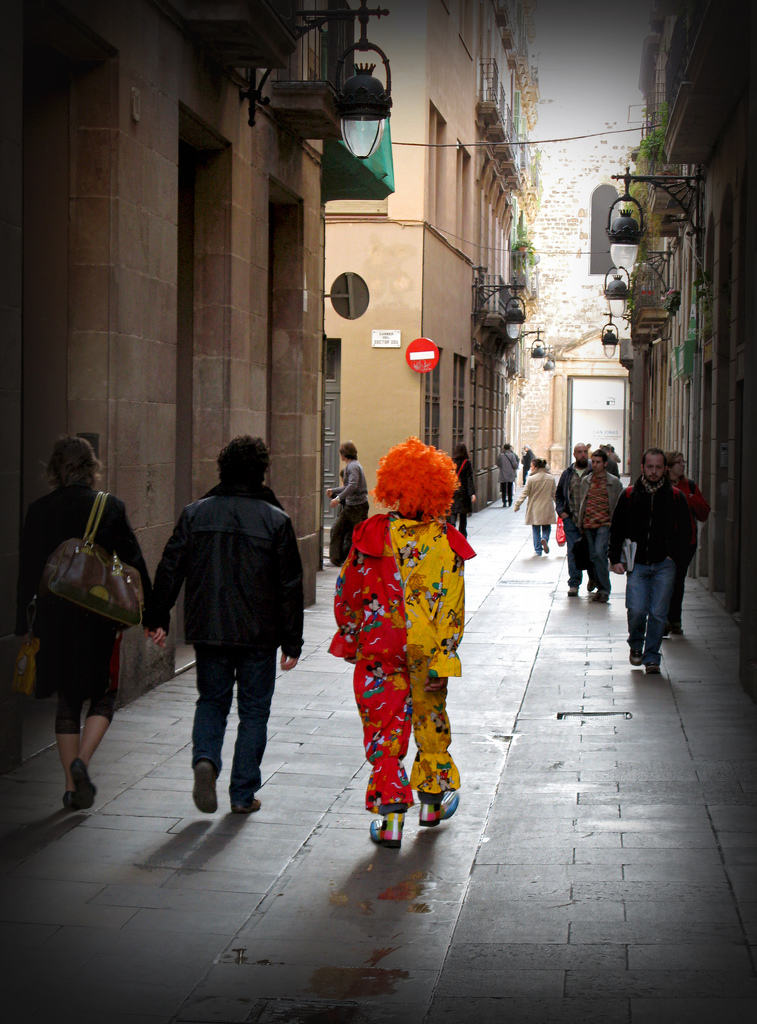 imagen de calle con ciudadanos caminando, uno vestido de payaso