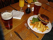 A pint, a pie and French fries with some peas.
