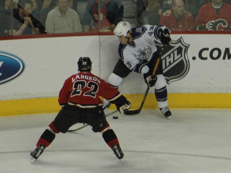 Los Angeles Kings' Mike Weaver battling for the puck against Calgary Flames' Daymond Langkow, December 21, 2005.