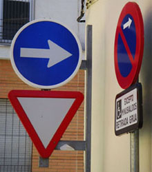 Triple señal de tráfico; ceda el paso, sentido obligatorio y prohibido estacionar