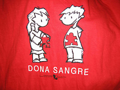 Camiseta roja con el dibujo de dos chicos y el lema "dona sangre"
