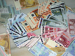Billetes de euros esparcidos por una mesa