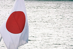 Bandera de Japón de una embarcación y al fondo un lago