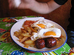 Plato con patatas fritas, chorizo frito y dos huevos fritos.