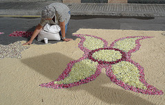 Mujer haciendo una alfombra de flores
