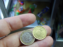 Mano con dos monedas; una de 1€ y otra de 20 cent